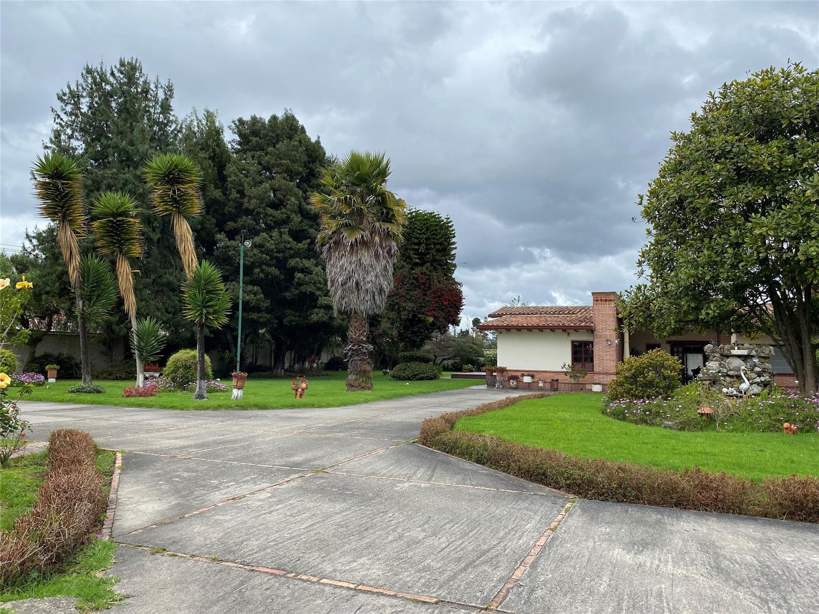 A paved driveway leads to a house with a tiled roof and landscaped garden — NOT IN USA Not In Usa Guaymaral- Colombia, FL