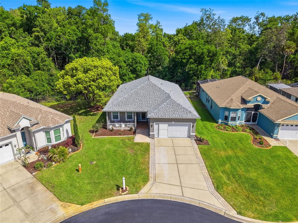 An aerial view shows a single-story house with a gray roof and concrete driveway — 11303 CLEAR OAK CIRCLE, NEW PORT RICHEY, FL