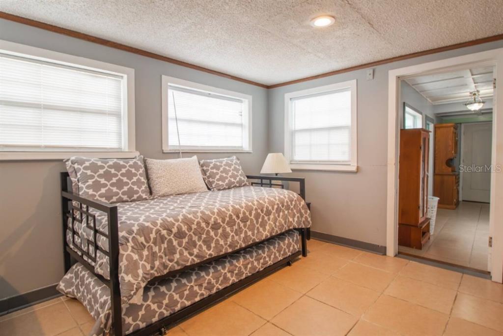 A bedroom with tile flooring, a daybed, and windows looking into an adjacent hallway — 1731 GRAYSON DRIVE UNIT 2, ORLANDO, FL
