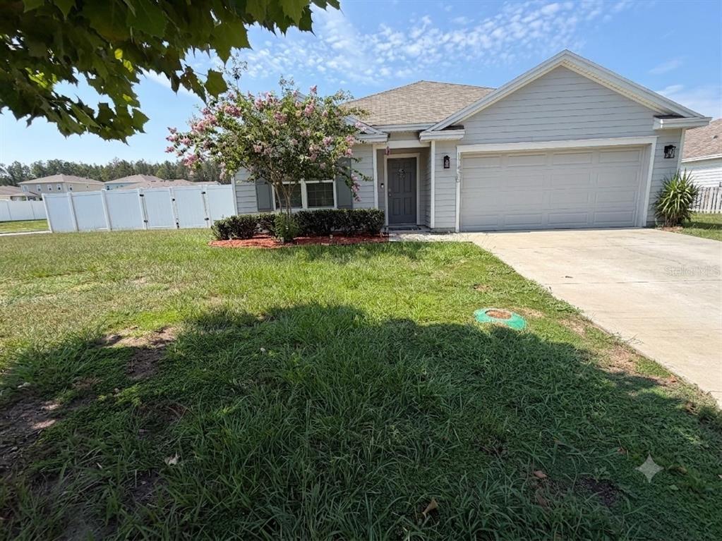 A single-story house with light gray siding, a two-car garage, and a front yard — 17425 NW 173 ROAD, ALACHUA, FL
