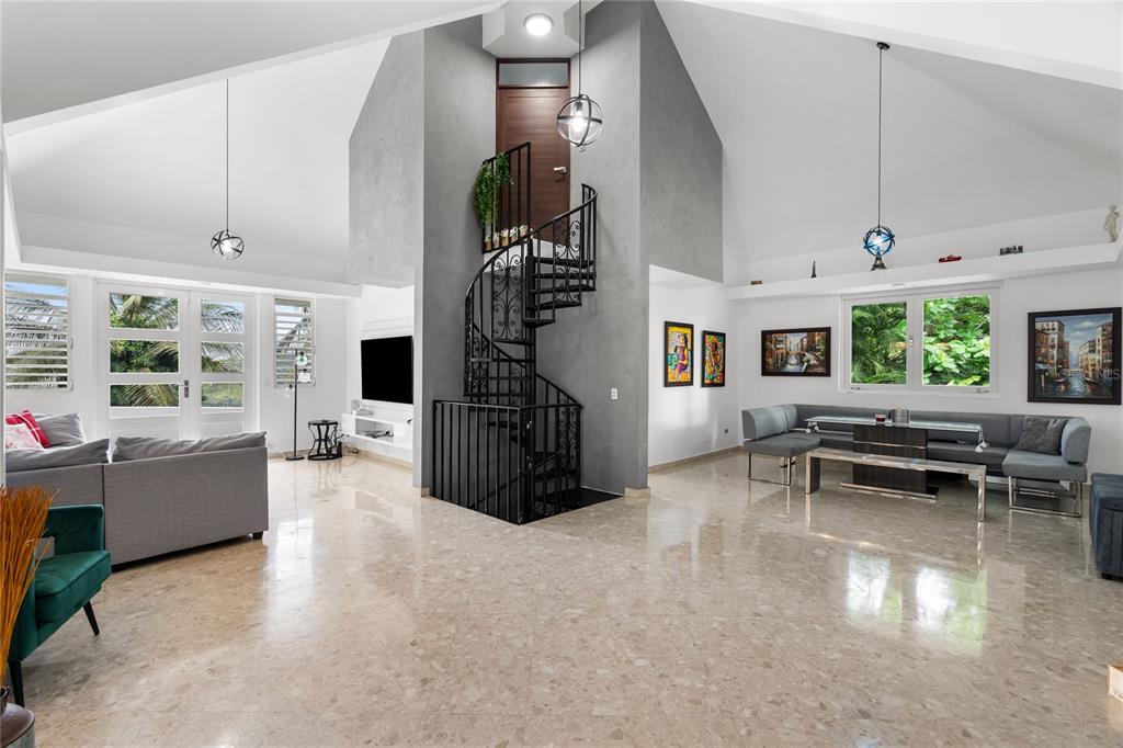 A spacious living room features a spiral staircase, vaulted ceilings, and polished marble flooring — 19 CALLE "E", GUAYNABO, PR