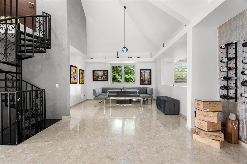 A spacious room features a spiral staircase, marble flooring, a dining nook, and wall-mounted wine racks — 19 CALLE "E", GUAYNABO, PR