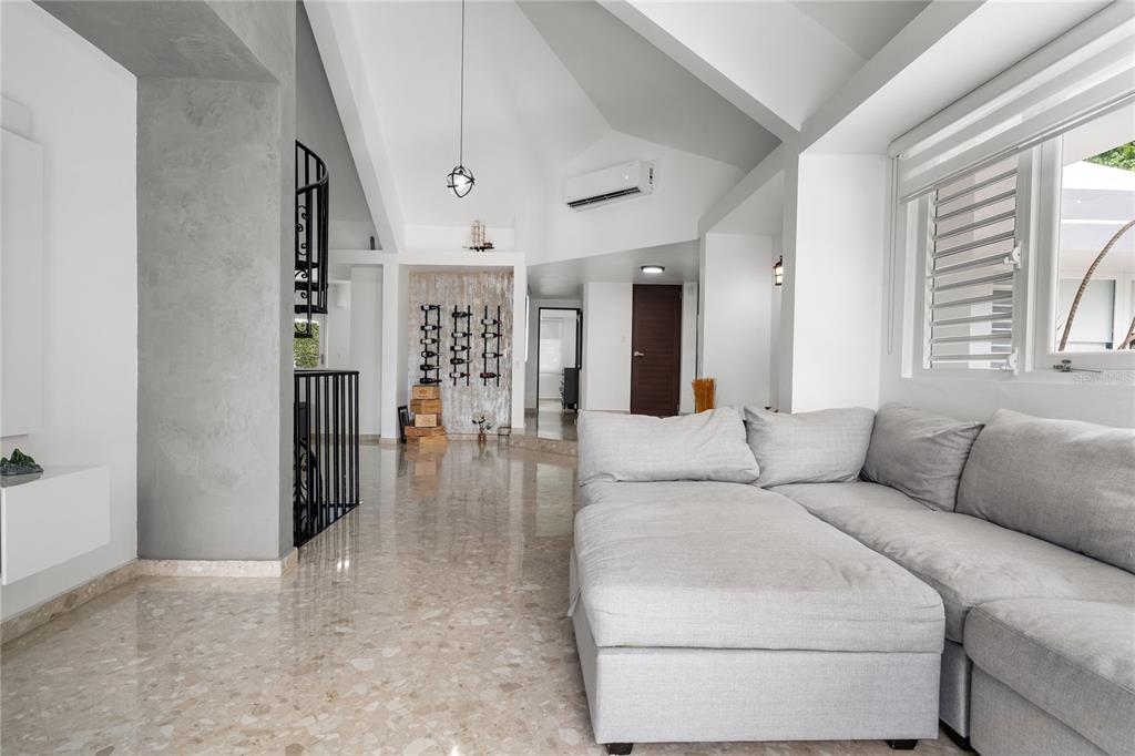 A living room with a gray sectional sofa, marble floors, and a vaulted ceiling — 19 CALLE "E", GUAYNABO, PR