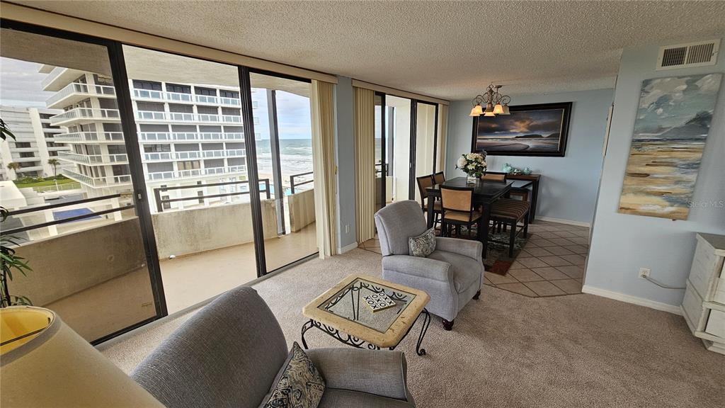 A living and dining area features floor-to-ceiling windows with a view of the ocean — 2900 N ATLANTIC AVENUE UNIT 305, DAYTONA BEACH, FL