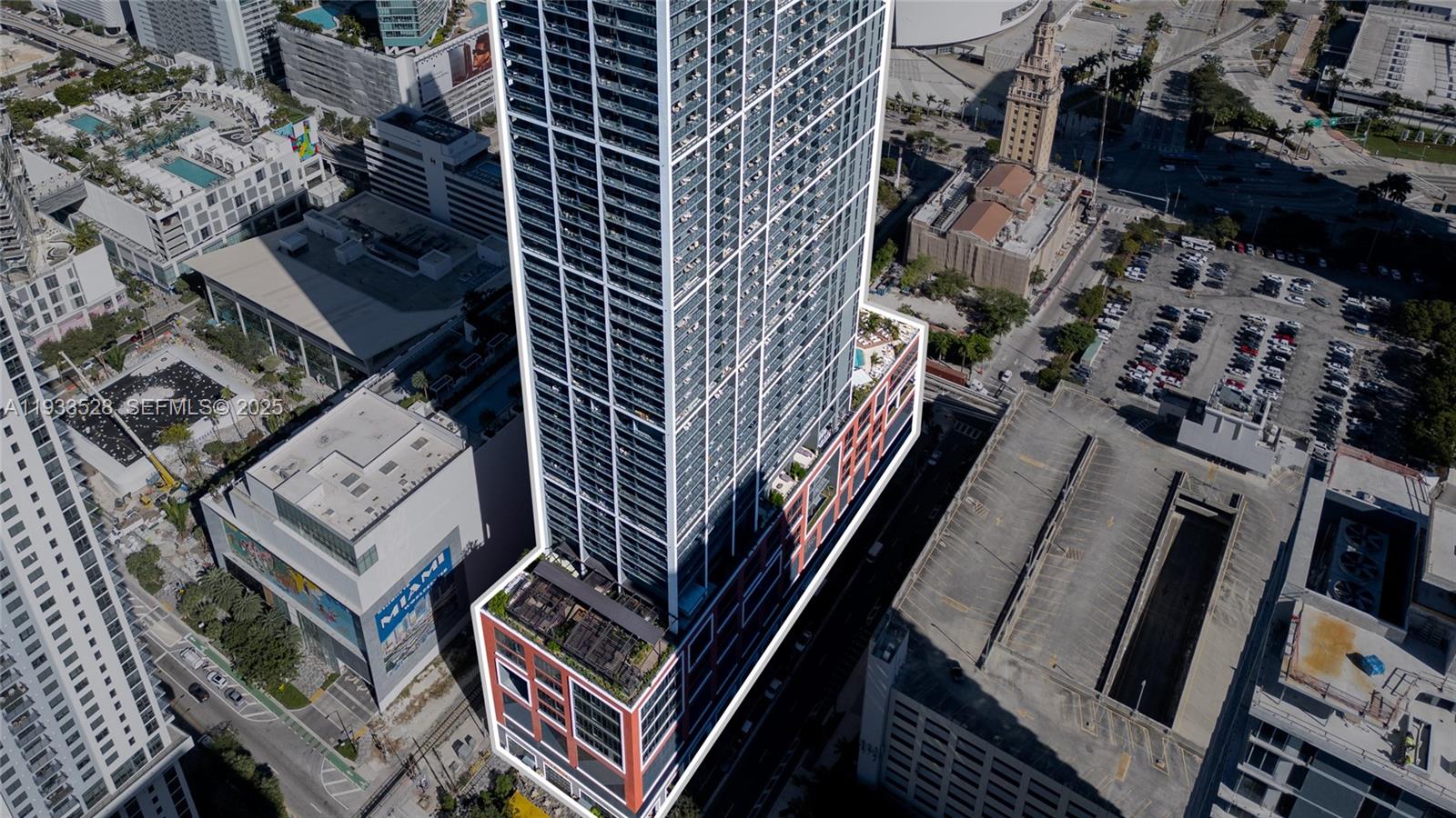 An aerial view shows a tall skyscraper in an urban setting with adjacent parking structures — 601 NE 1St Ave, Miami FL 33132, MIAMI, FL