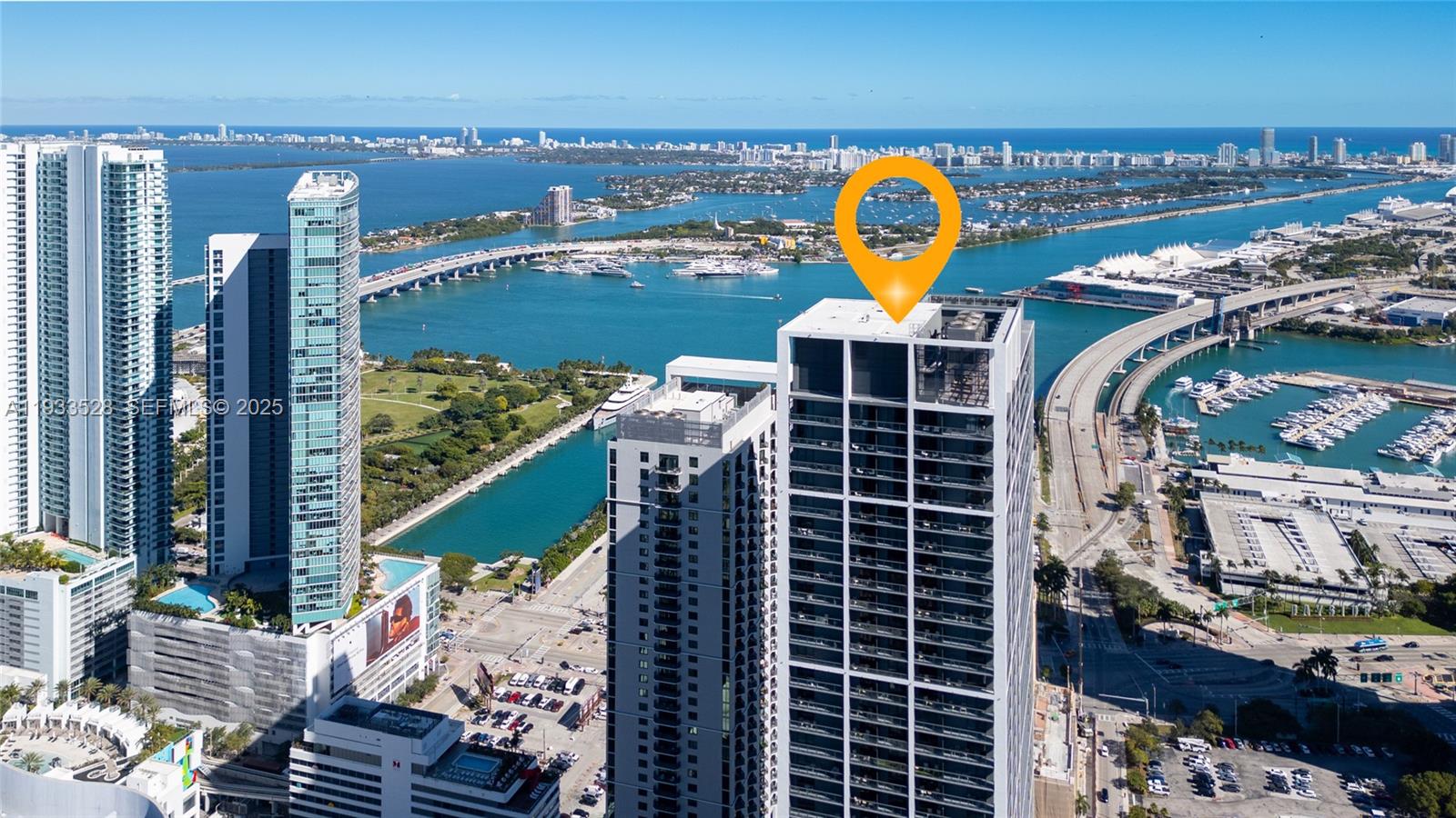 An aerial view shows high-rise apartment buildings near a bay with bridges and boats — 601 NE 1St Ave, Miami FL 33132, MIAMI, FL