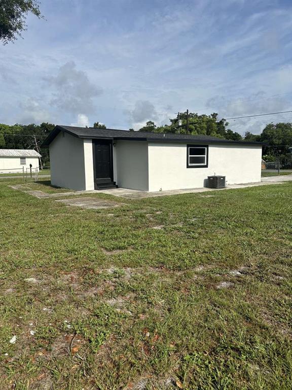 The exterior of a single-story house with a black door and a small window — 3329 LYNN DRIVE, LAKELAND, FL