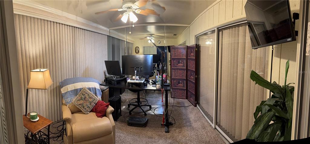 This home office features a desk, a recliner, vertical blinds, and a mirrored wall — 7309 ELEANOR CIRCLE UNIT 7309, SARASOTA, FL