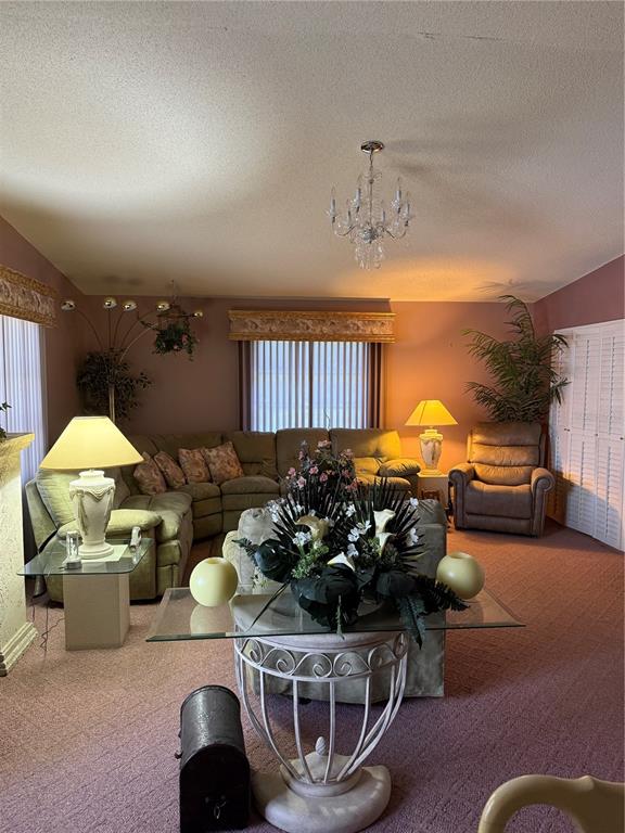 A living room features a sectional sofa, a glass-topped table, and mauve wall-to-wall carpeting — 7309 ELEANOR CIRCLE UNIT 7309, SARASOTA, FL