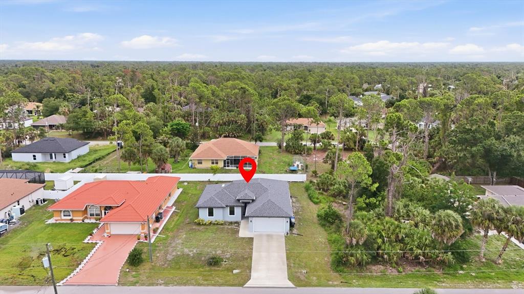 An aerial view shows a single-story house with a gray roof and a concrete driveway — 4746 GLOBE TERRACE, NORTH PORT, FL