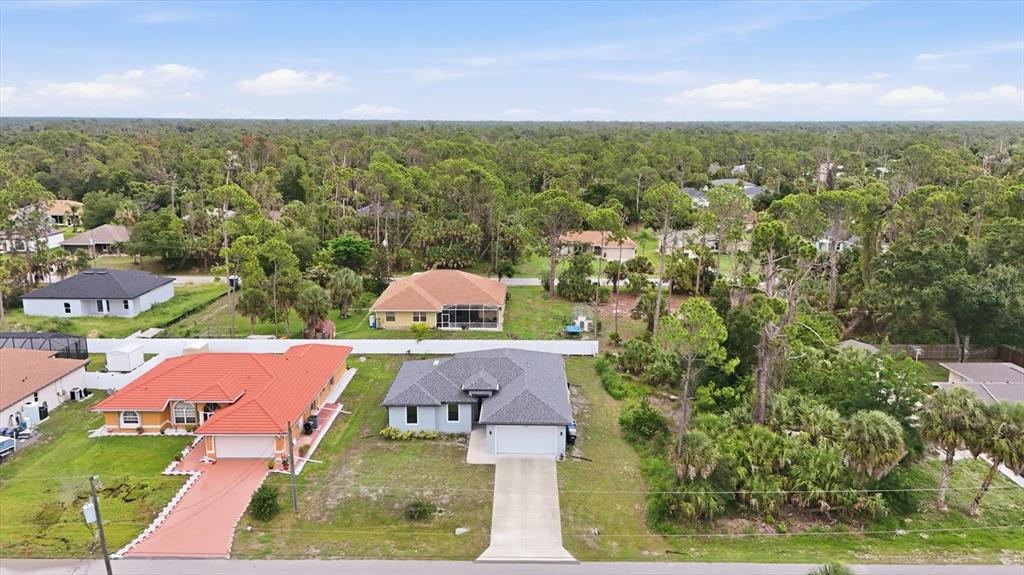 An aerial view shows a residential street with a gray-roofed house beside a red-roofed house — 4746 GLOBE TERRACE, NORTH PORT, FL
