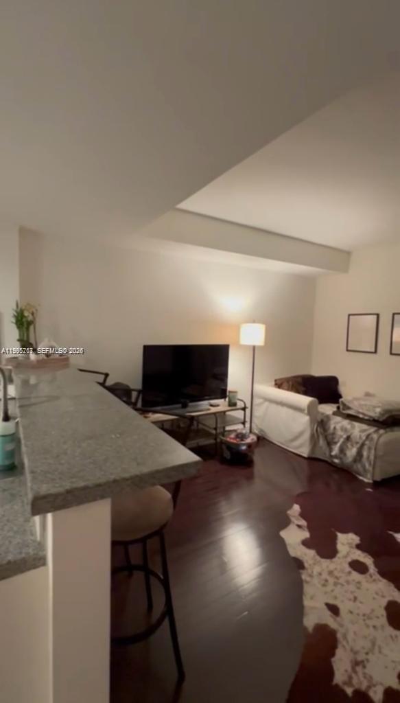 A living room features dark hardwood floors, a white sofa, and a granite breakfast bar — 2740 SW 28th Ter # 503, Miami FL 33133, MIAMI, FL