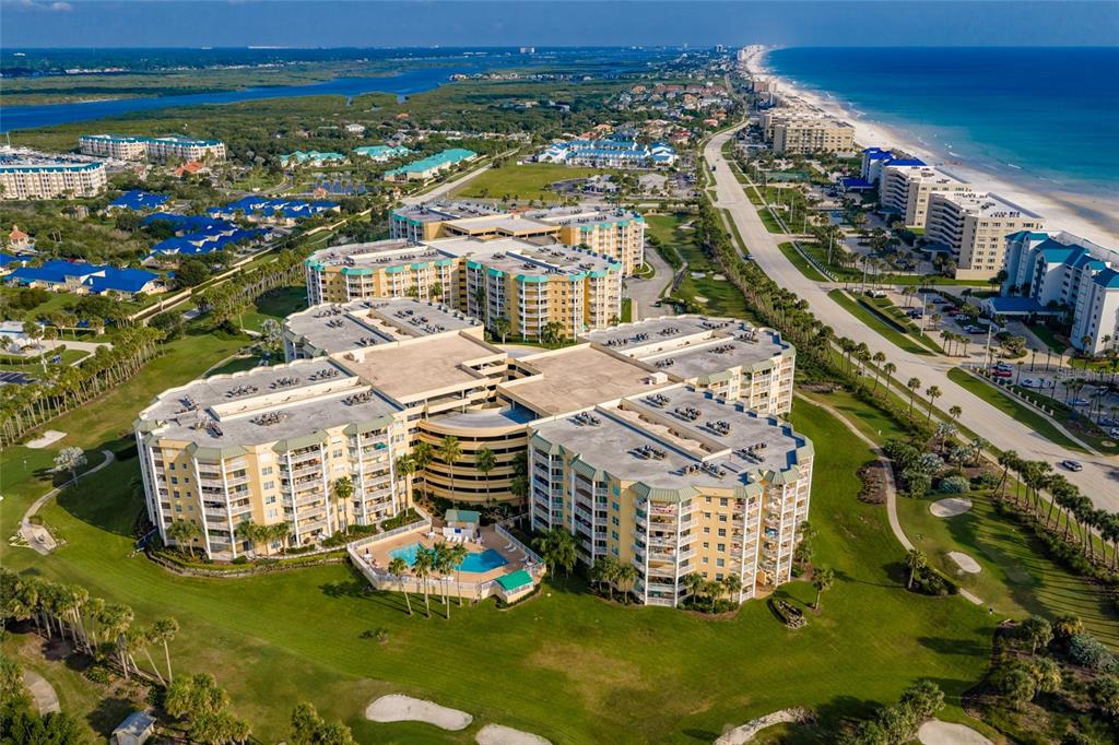 An aerial view of a large multi-story apartment complex surrounded by a golf course — 4650 LINKS VILLAGE DRIVE UNIT D501, PONCE INLET, FL