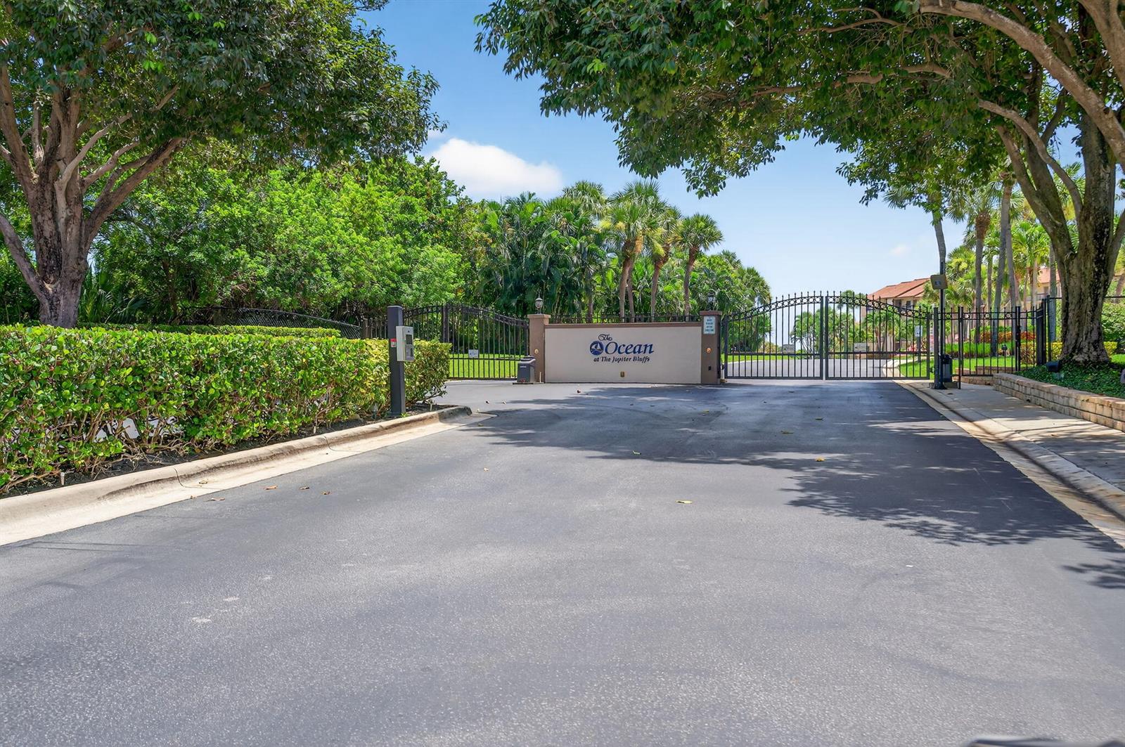 A gated entrance with a sign reading The Ocean at The Jupiter Bluffs — 401 Ocean Bluffs Boulevard # 205, Jupiter FL 33477, JUPITER, FL