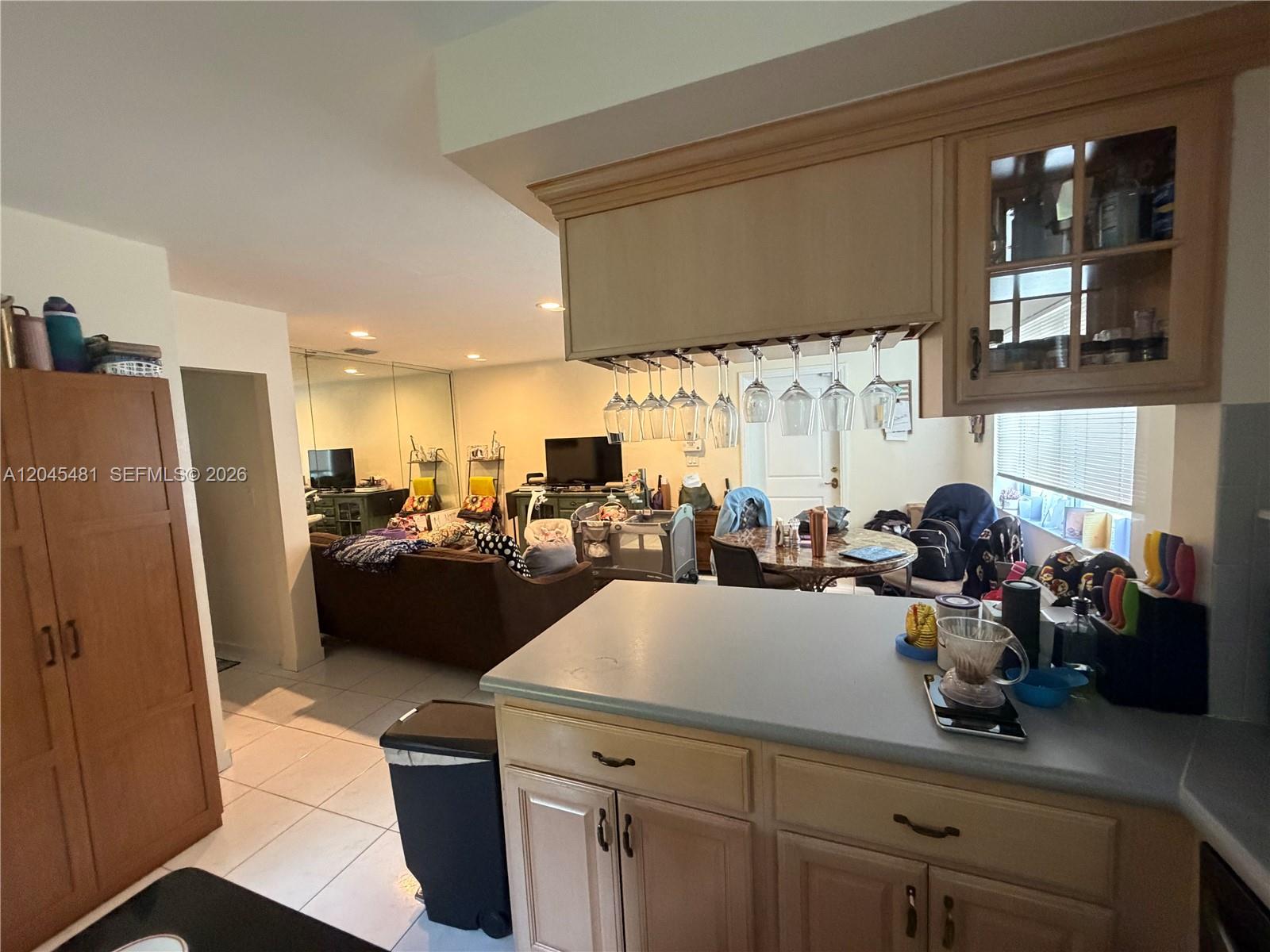 A kitchen with light wood cabinets and a breakfast bar overlooks a living area — 2862 SW 38 Ave, Miami FL 33134, MIAMI, FL