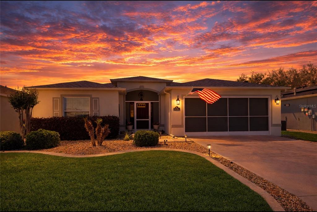 A single-story house with a garage and an American flag at sunset — 16304 SW 12TH TERRACE, OCALA, FL