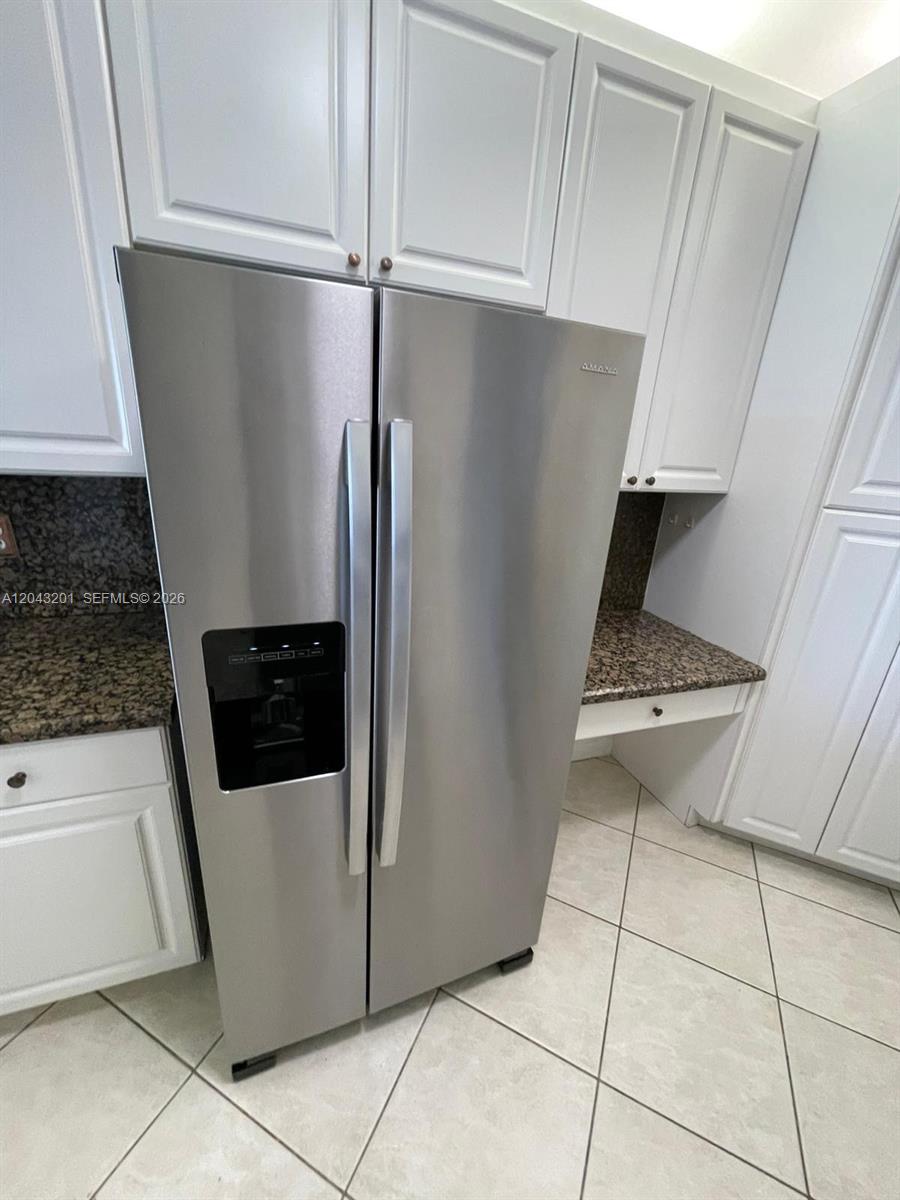 An empty room with light-colored tile flooring, a ceiling light, and a sliding glass door — 10720 NW 66th ST # 503, Doral FL 33178, DORAL, FL
