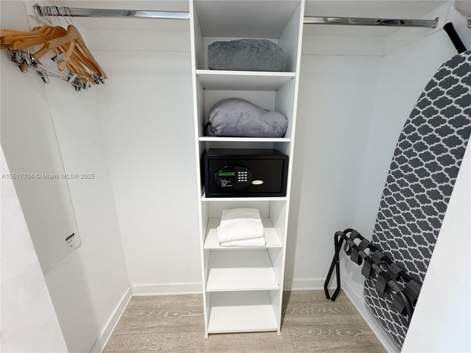 A closet features a central shelving unit with a safe, towels, and hanging space — 2602 E Hallandale Beach Blvd # 1708, Hallandale Beach FL 33009, HALLANDALE BEACH, FL