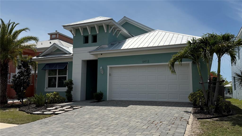 A teal, single-story house with a metal roof and a paved driveway — 6412 GRENADA ISLAND AVENUE, APOLLO BEACH, FL