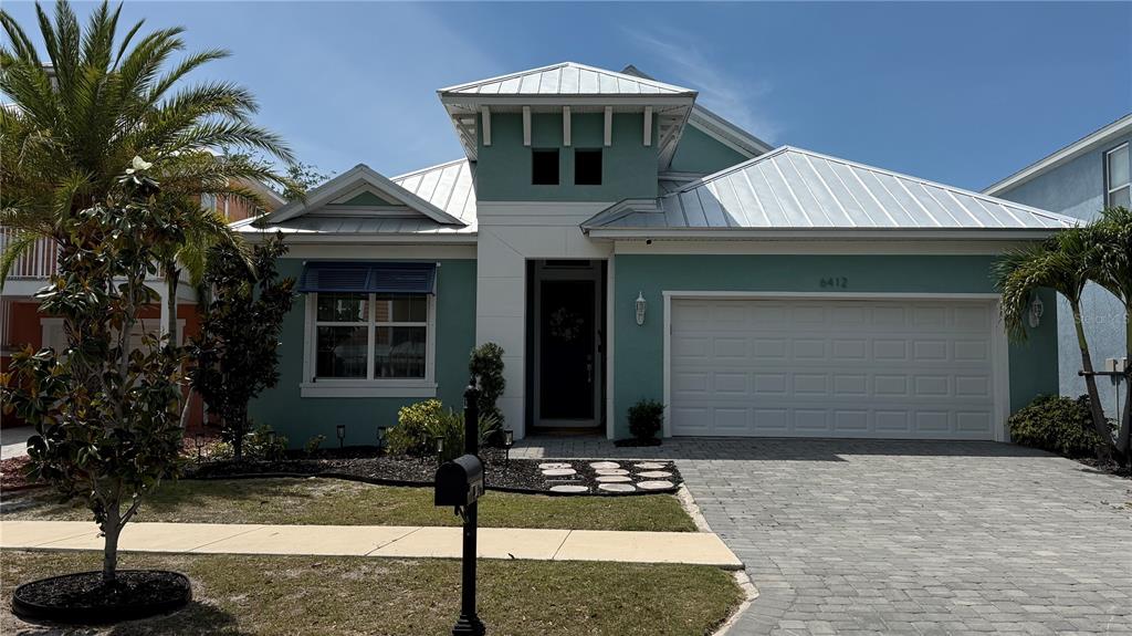 A teal, single-story house with a metal roof and a paved driveway — 6412 GRENADA ISLAND AVENUE, APOLLO BEACH, FL