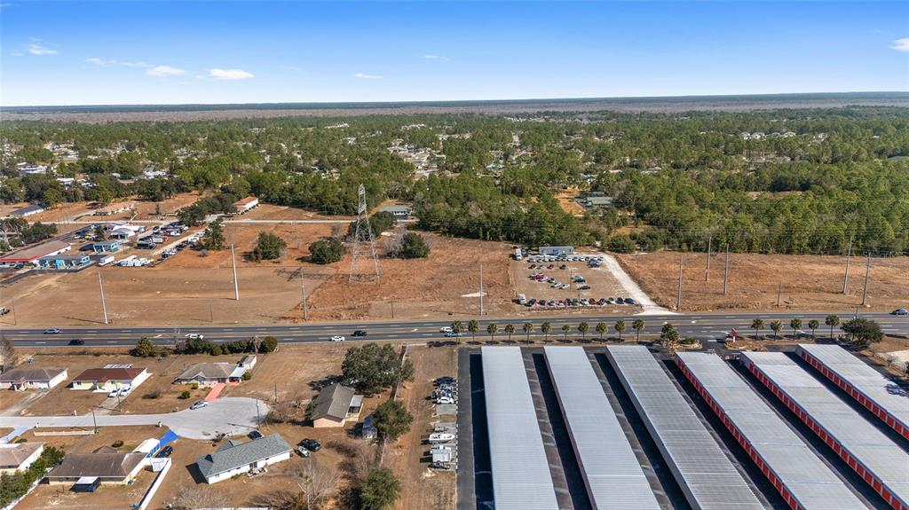An aerial view shows a large storage facility, a highway, and surrounding residential and wooded areas — LOT 15 & 16 SE MARICAMP ROAD, OCALA, FL