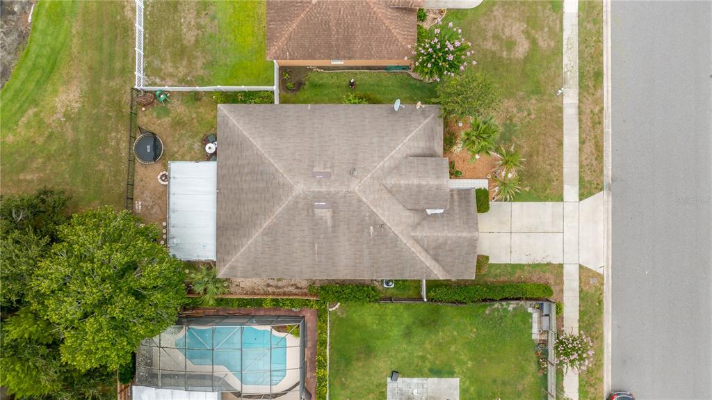 An aerial view shows a house with a shingled roof, a pool, and a driveway — 12827 WOODBURY GLEN DRIVE, ORLANDO, FL