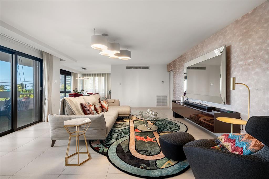 A balcony with artificial turf, a hanging chair, and a view of trees and ocean — 1510 ASHFORD AVENUE UNIT 3, SAN JUAN, PR