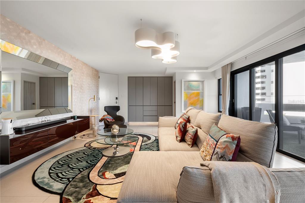 A modern living room features a sectional sofa, a patterned area rug, and a large mirror — 1510 ASHFORD AVENUE UNIT 3, SAN JUAN, PR