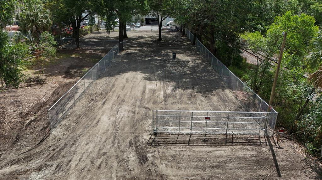 An aerial view of a fenced, cleared rectangular lot with tire tracks on the ground — 208 S FRANKLIN STREET, PLANT CITY, FL
