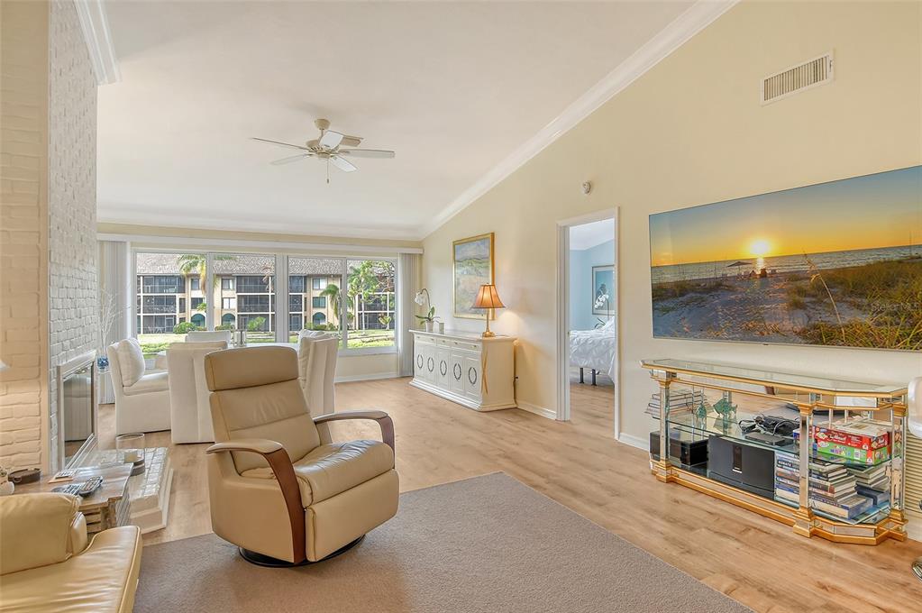 A living room features a fireplace, a recliner, a television, and large windows with exterior views — 5644 ASHTON LAKE DRIVE UNIT 5644, SARASOTA, FL