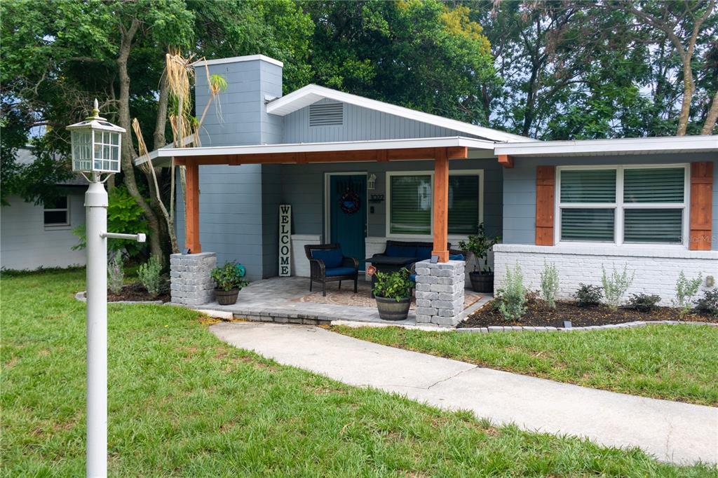 A blue house with a covered front porch, stone pillars, and a concrete walkway — 1022 S TOWER LANE, LAKE WALES, FL