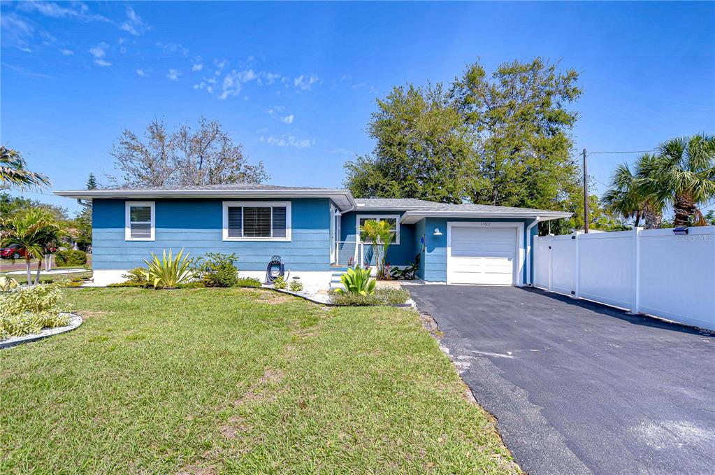A blue single-story house with a white garage door and a paved driveway — 1922 55TH STREET S, GULFPORT, FL