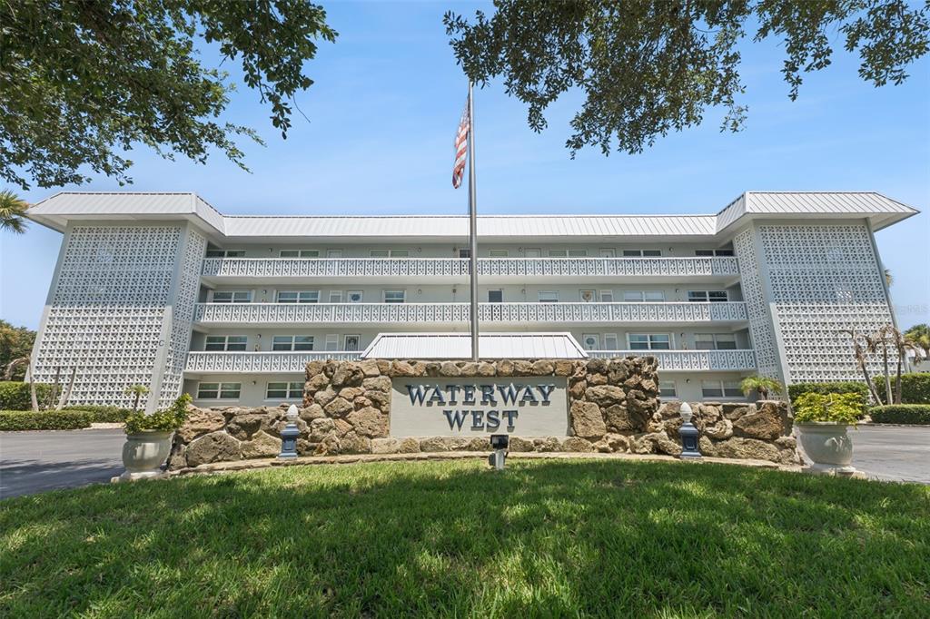 A three-story apartment building with a stone sign reading Waterway West in the foreground — 315 N CAUSEWAY UNIT B302, NEW SMYRNA BEACH, FL