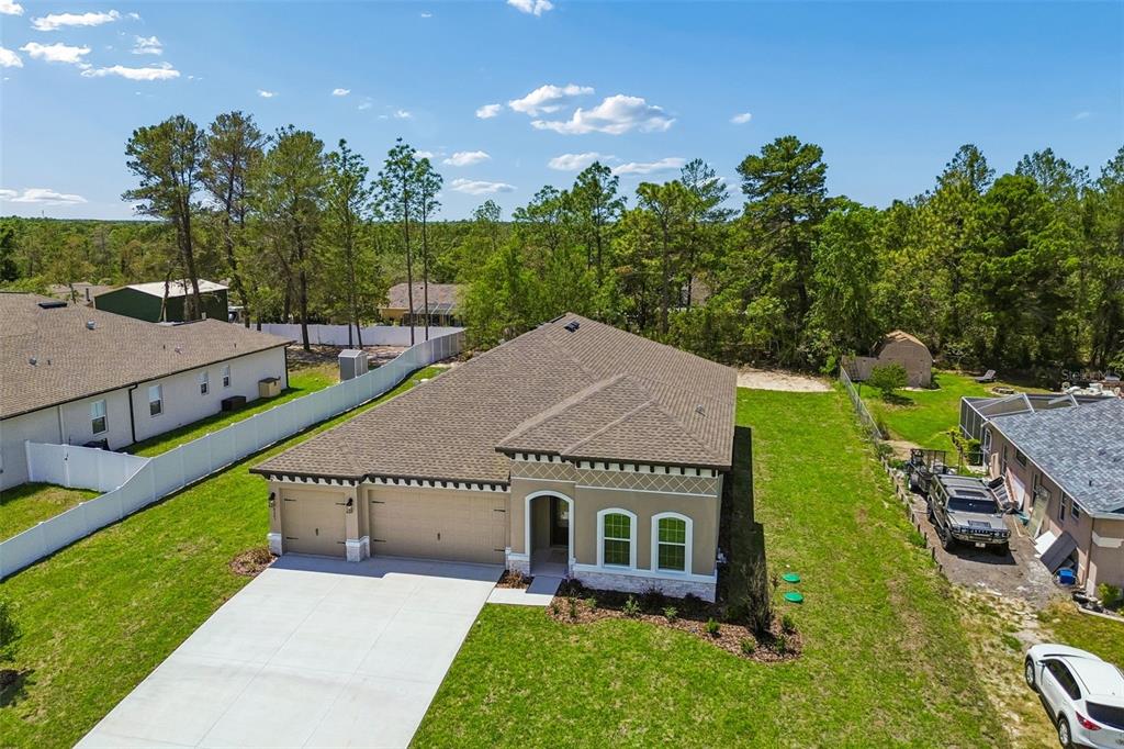 An aerial view of a tan single-story house with a two-car garage and driveway — 8283 NITTANY ROAD, WEEKI WACHEE, FL