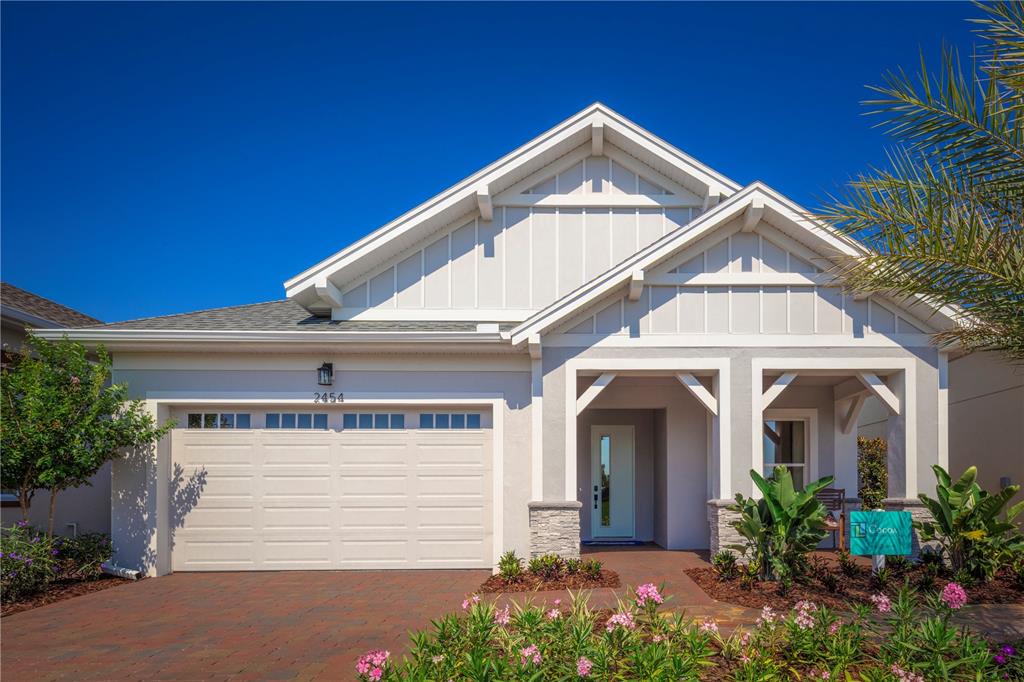 A single-story house with a two-car garage, stone accents, and a covered front entryway — 2454 DREAM HOME COURT, ST CLOUD, FL