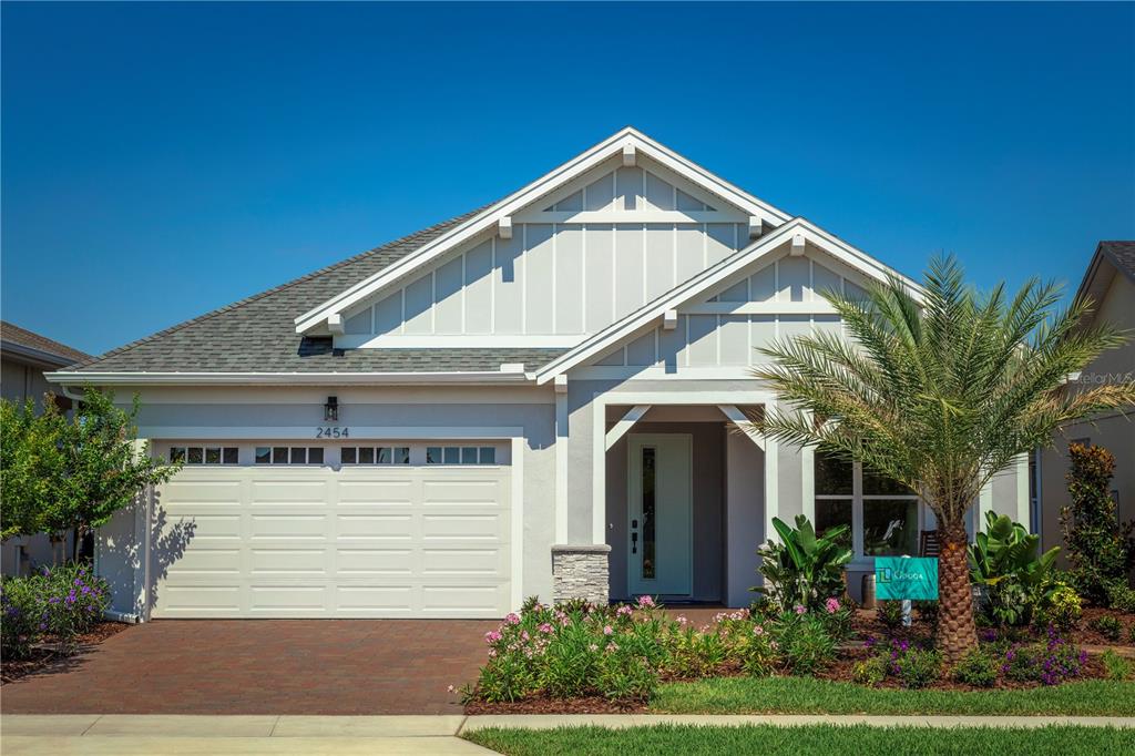 A single-story house with a white garage, light-colored siding, and a palm tree in front — 2454 DREAM HOME COURT, ST CLOUD, FL
