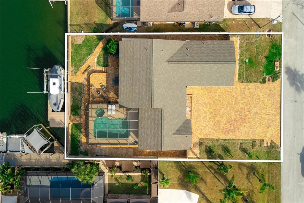 An aerial view shows a house with a pool, patio, and boat dock on a canal — 5 CHEYENNE COURT, PALM COAST, FL