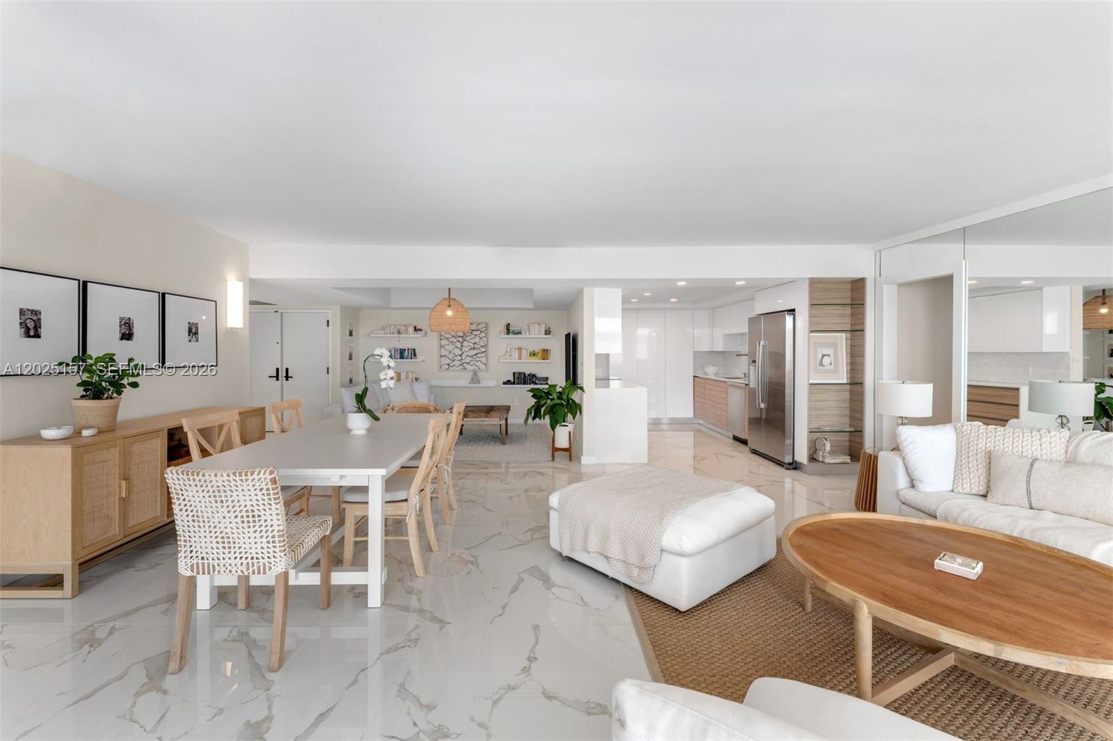 An open-concept living and dining area features white marble flooring, modern furniture, and a kitchen — 3 Grove Isle Dr # C803, Miami FL 33133, MIAMI, FL