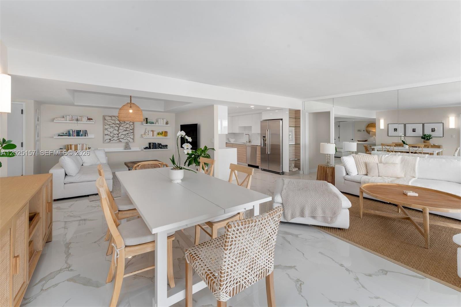 An open-concept living and dining area features white marble floors and modern neutral furnishings — 3 Grove Isle Dr # C803, Miami FL 33133, MIAMI, FL