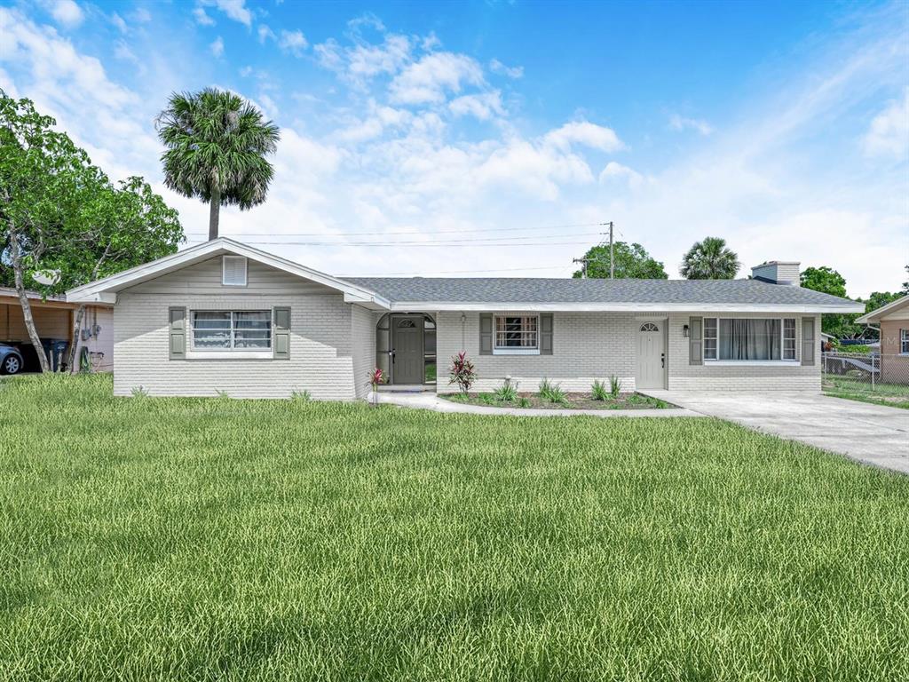 A single-story, light gray brick house with a front lawn and a concrete driveway — 1818 6TH STREET SE, WINTER HAVEN, FL