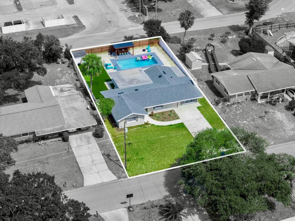 An aerial view shows a single-story house with a backyard pool and a fenced lawn — 1818 6TH STREET SE, WINTER HAVEN, FL