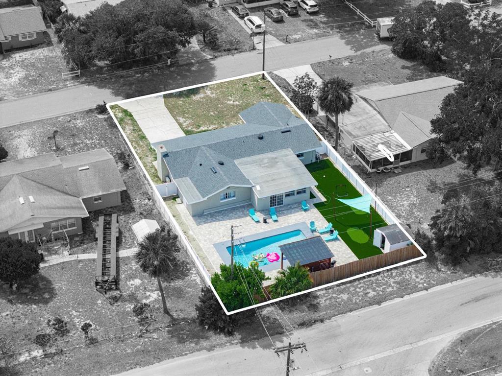 An aerial view shows a house with a swimming pool, patio, and artificial turf yard — 1818 6TH STREET SE, WINTER HAVEN, FL