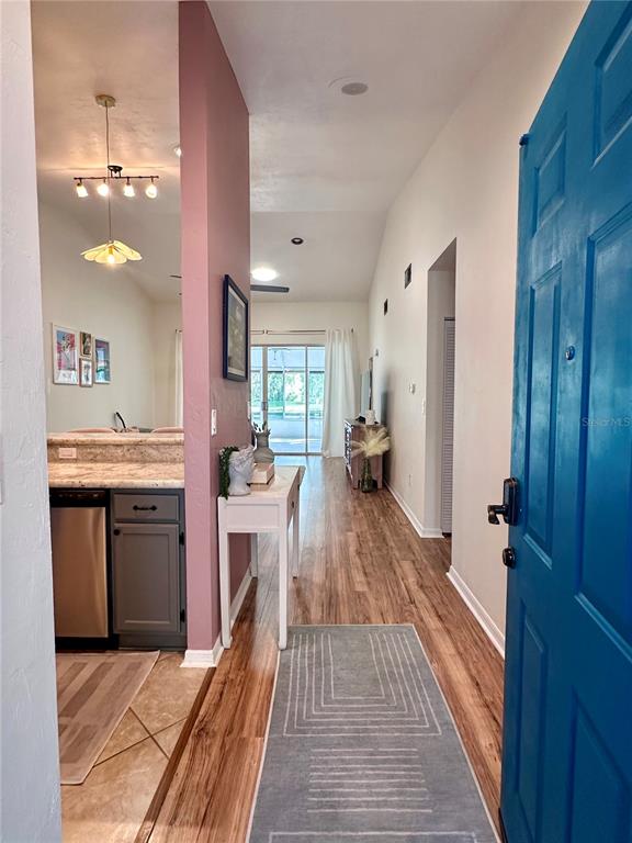 An entryway with a blue door leads into a living area with wood-look flooring — 824 NW 124TH DRIVE, NEWBERRY, FL