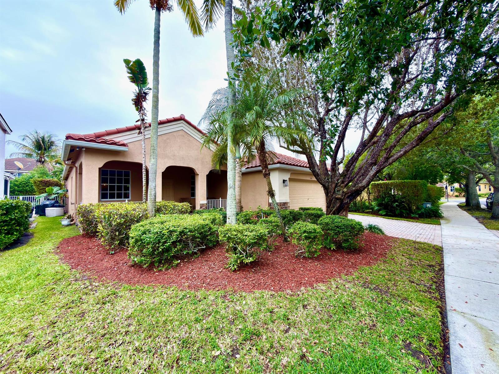 A single-story stucco house with a tile roof, palm trees, and a landscaped front yard — 1618 Royal Grove Way, Weston FL 33327, WESTON, FL