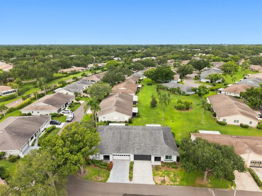 An aerial view shows a residential neighborhood with several single-story homes and green lawns — 1425 LELAND DRIVE, SUN CITY CENTER, FL