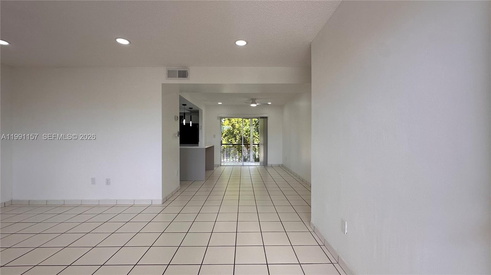An open-concept living area features white walls, tiled floors, and a sliding glass door — 8401 SW 107th Ave # 331E, Miami FL 33173, MIAMI, FL