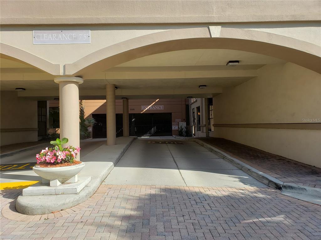 A paved driveway leads to a parking garage entrance with a seven-foot-five-inch clearance sign — 402 S ARMENIA AVENUE UNIT 114, TAMPA, FL