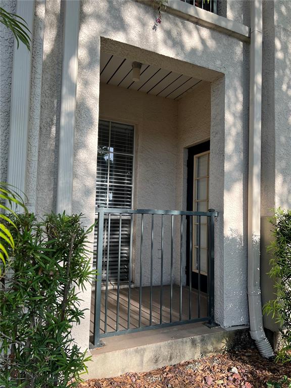 A ground-level entryway features a metal railing, a window with blinds, and a glass-paneled door — 402 S ARMENIA AVENUE UNIT 114, TAMPA, FL
