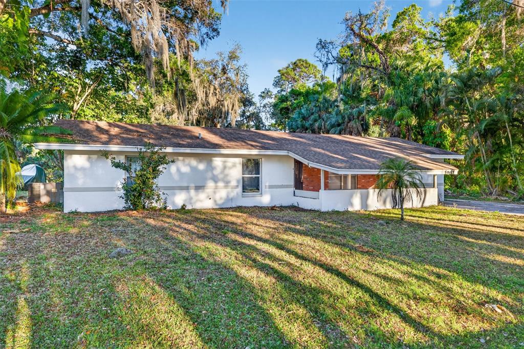 A single-story house with a white exterior, brick accents, and a brown shingled roof — 1941 BROWN ROAD, ALVA, FL