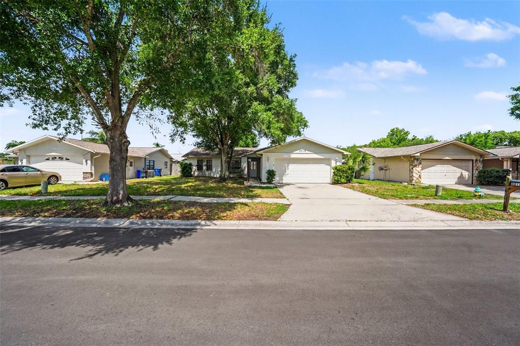 A single-story suburban house with a two-car garage and a large tree in the yard — 4816 W ADDAX DRIVE, NEW PORT RICHEY, FL